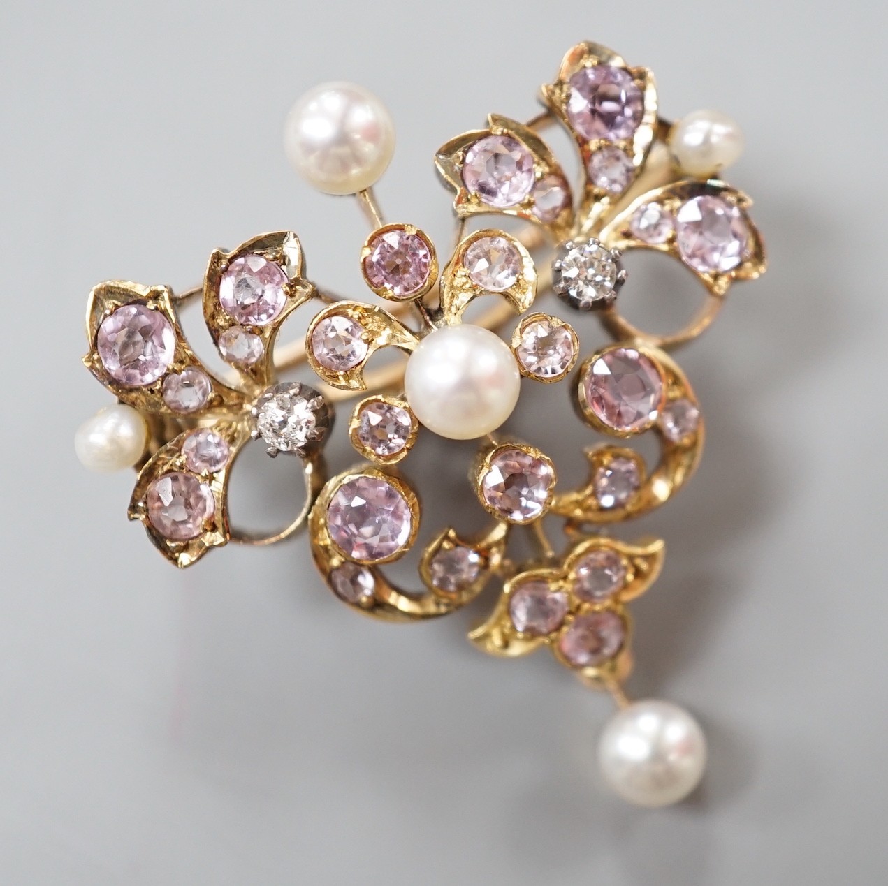 An early 20th century yellow metal, diamond, cultured pearl and pink topaz? cluster set pendant brooch, width 30mm, gross weight 9.1 grams.